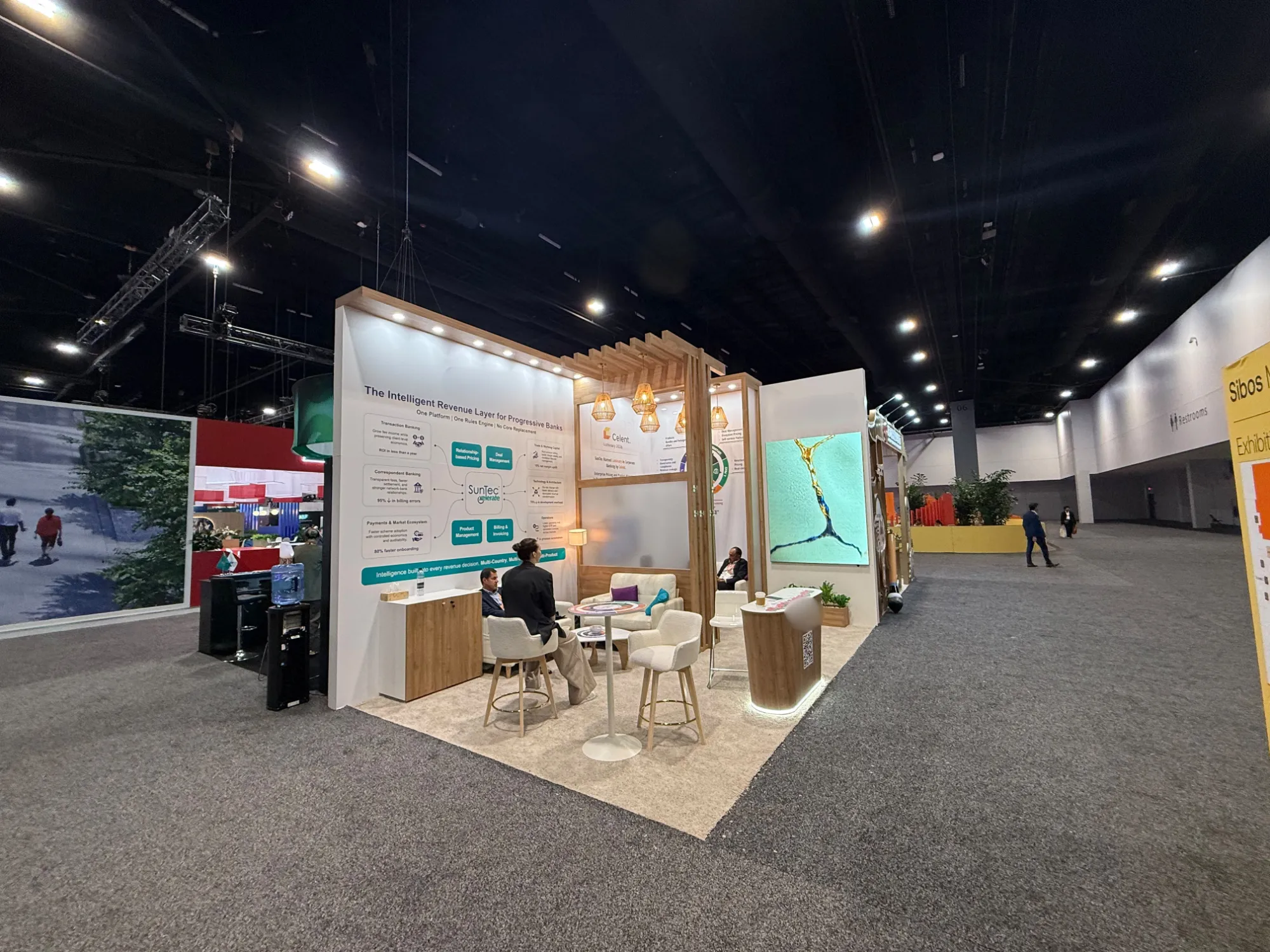 Warm wood and white exhibition stand with lounge area and large LED screen at SIBOS 2026, Miami
